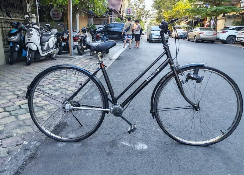 Xe đạp trục láp cũ khung đen chụp ngang bên đường