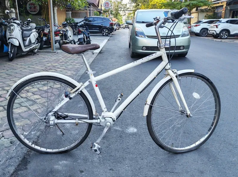 Xe đạp trục láp cũ khung trắng chụp toàn xe từ bên hông